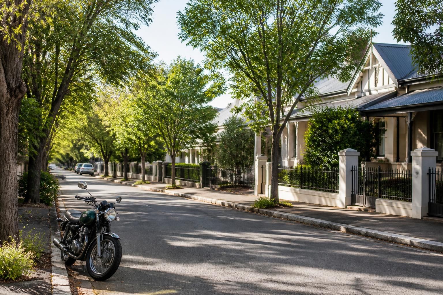Adelaide street with parked motorcycle and leafy surroundings.